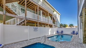 A pool area with two pools, a wooden deck, and a white fence with a lifeguard sign. - ACROSS FROM the BEACH SLEEPS 50, HUGE POOL+SPA, CHEF'S KITCHEN, GAME+MEDIA ROOM (North Myrtle Beach)