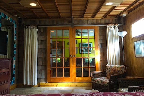 Bedroom looking towards living room. Beautiful restored sliding french doors.