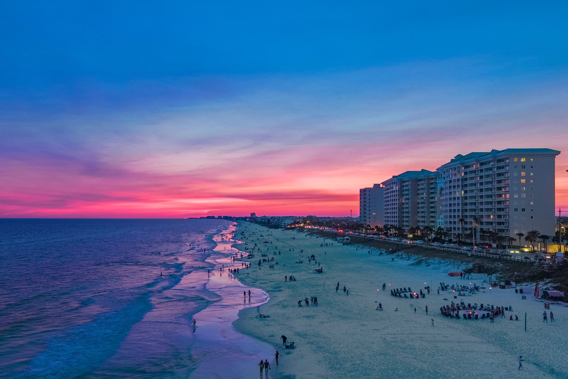 A beach with a hotel in the background.