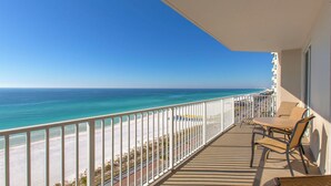 Un balcon avec vue sur la plage et l’océan.