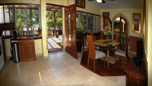 A spacious kitchen with a dining area, large windows, and a ceiling fan.