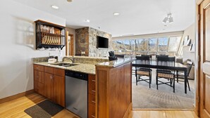 A modern kitchen with granite countertops, wooden cabinets, and a built-in dishwasher. - Mountain-View Penthouse w/ convenient access to Grand Hyatt Vail (Vail)