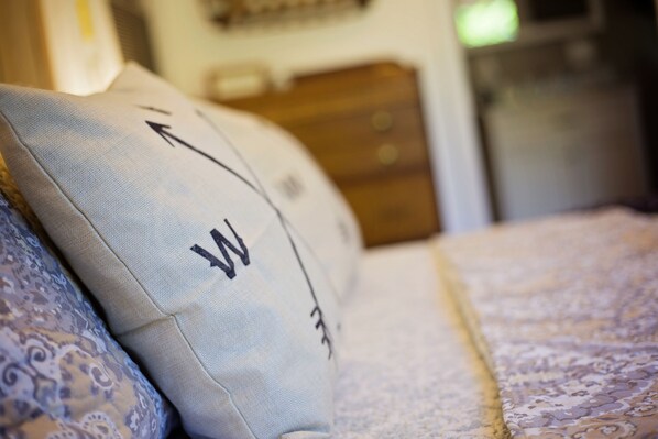 Un gros plan d’un coussin orné d’un motif en tissu et d’un lit recouvert d’une couvre-lit à motifs.