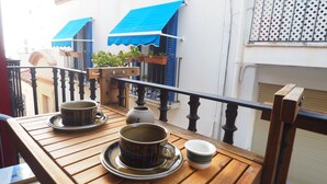 A wooden table with tea cups and saucers on a balcony. - Balcony View Apartment by Hello Homes Sitges (Sitges)
