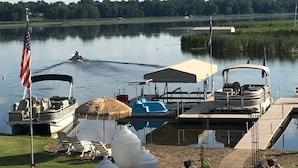 Un moll al costat d'un llac amb barques, una zona coberta i una bandera.