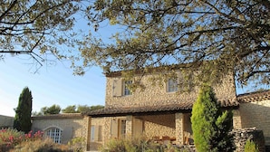 A stone building with a tiled roof, two windows, and a small porch area. - Gordes/Goult - Stunning Mas Provençal On A Hill In Luderon (Goult)