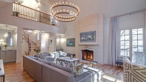 Ein geräumiges Wohnzimmer mit einer großen Eckcouch, einem Kamin und einer Treppe zu einer oberen Ebene.