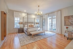 Relax in this serene bedroom with a four-poster bed, bedside tables, and a chandelier.
