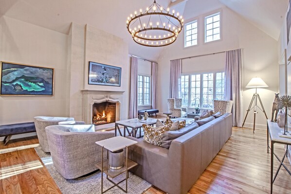 Cozy living space with a fireplace, sofa, and large windows.