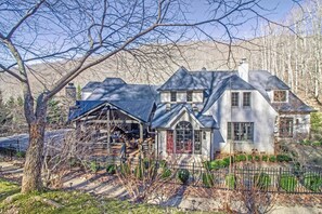 Stunning two-story home with a covered porch and beautifully manicured grounds.