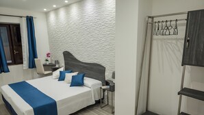 Un dormitorio moderno con cama, mesita de noche, silla, armario y zona de ducha.