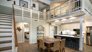A spacious kitchen with a dining area, wooden flooring, and a staircase leading to an upper level. - SeaPines, Stunning, Pet friendly, Golf view, Walk to SeaPines Beach Club (Hilton Head Island)