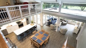 A spacious open-plan living area with a dining table, seating, and a view of the outdoors. - SeaPines, Stunning, Pet friendly, Golf view, Walk to SeaPines Beach Club (Hilton Head Island)