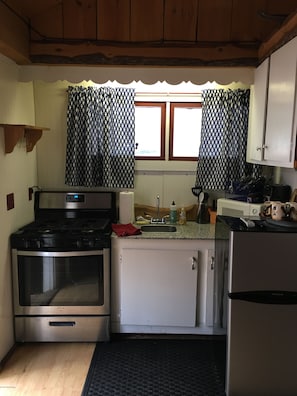 Una cocina compacta con estufa, horno, fregadero y refrigerador.