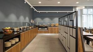 A modern breakfast bar with a variety of food items and a seating area with tables and chairs. - Four Points Flex by Sheraton Bochum (Bochum)