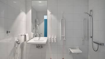 A modern bathroom with a sink, mirror, and shower.