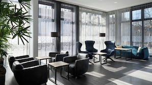 A modern hotel lobby with a seating area, large windows, and a potted plant. - Four Points Flex by Sheraton Bochum (Bochum)