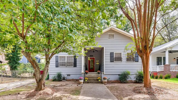 A single-story house with a front porch, a red door, and a small front yard with a pathway leading to the entrance. - Adorable Intown Duplex Close to Downtown Atlanta; 5 minute walk to Beltline (Atlanta)