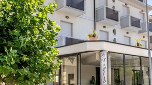 A multi-story hotel with a modern facade, balconies, and a glass entrance. - Hotel Tiglio (Rimini)