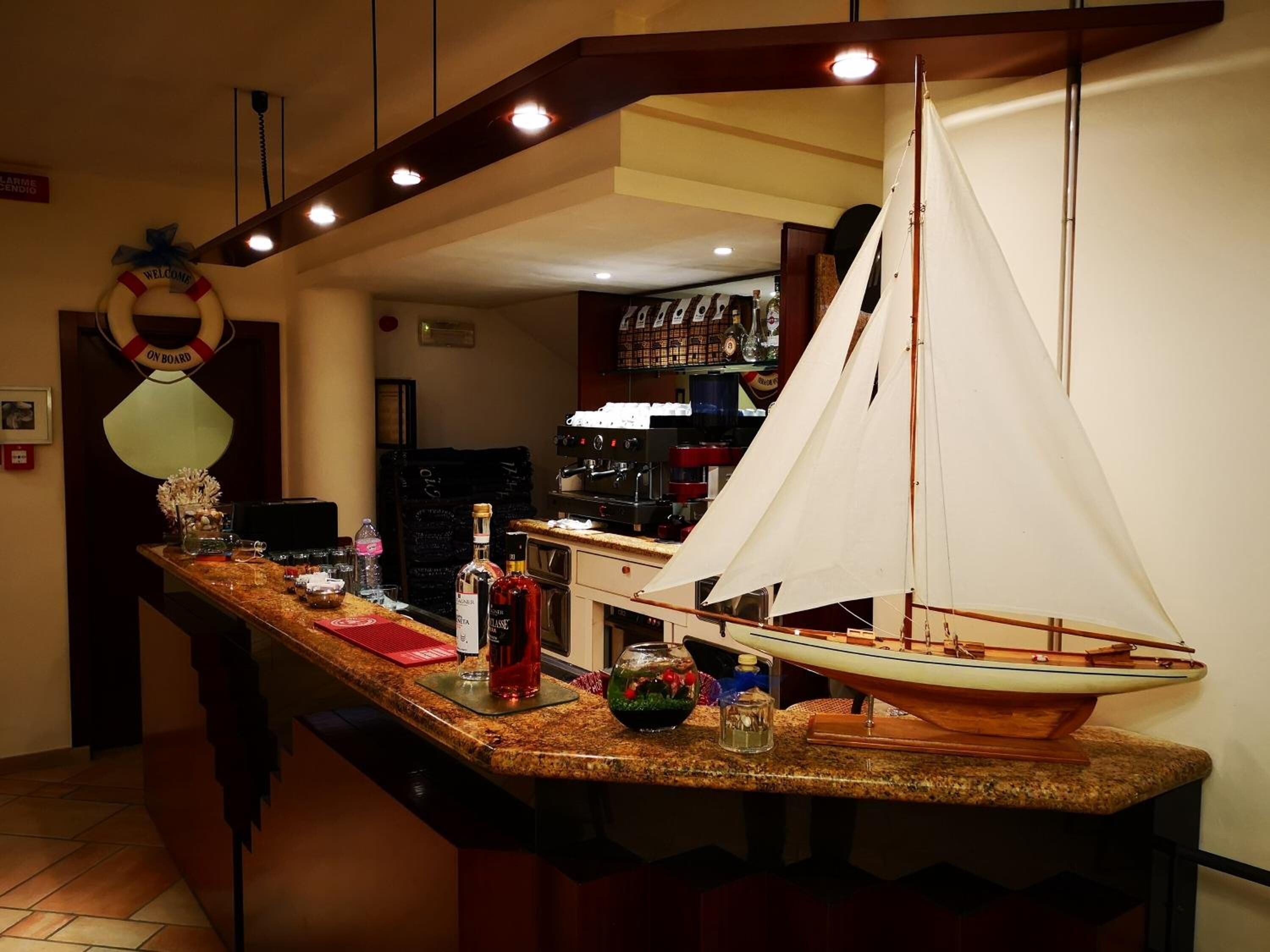 Eine Küche mit einem kleinen Modellboot auf der Arbeitsplatte, einem Willkommensschild und einer Bar mit Flaschen.