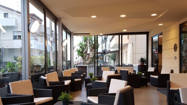 Un vaste espace extérieur aménagé avec des meubles en osier et des plantes en pot.