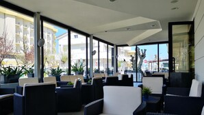 Un espace extérieur moderne, aménagé avec des meubles en osier et des plantes en pot.