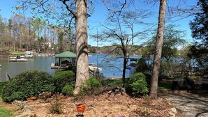 A lakeside park with a gazebo, picnic tables, and a barbecue grill.