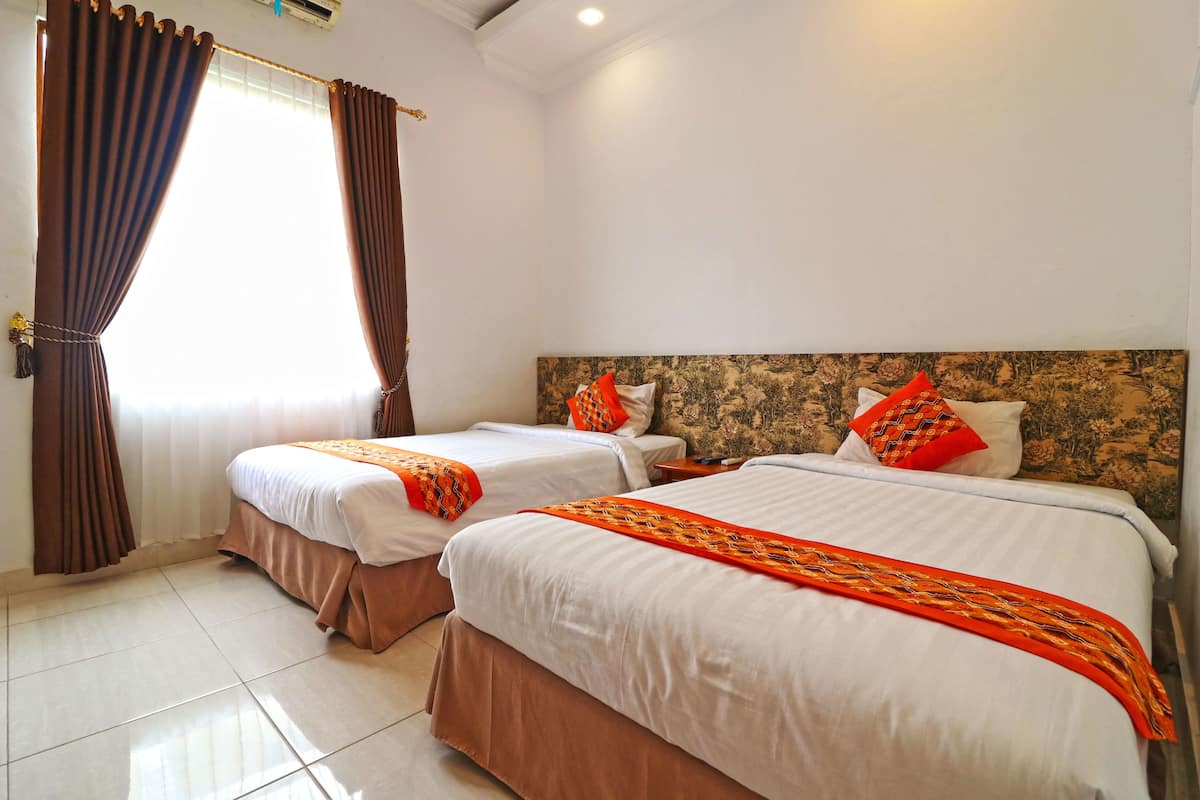 A hotel room with two beds, white bedding, brown curtains, and a floral headboard.