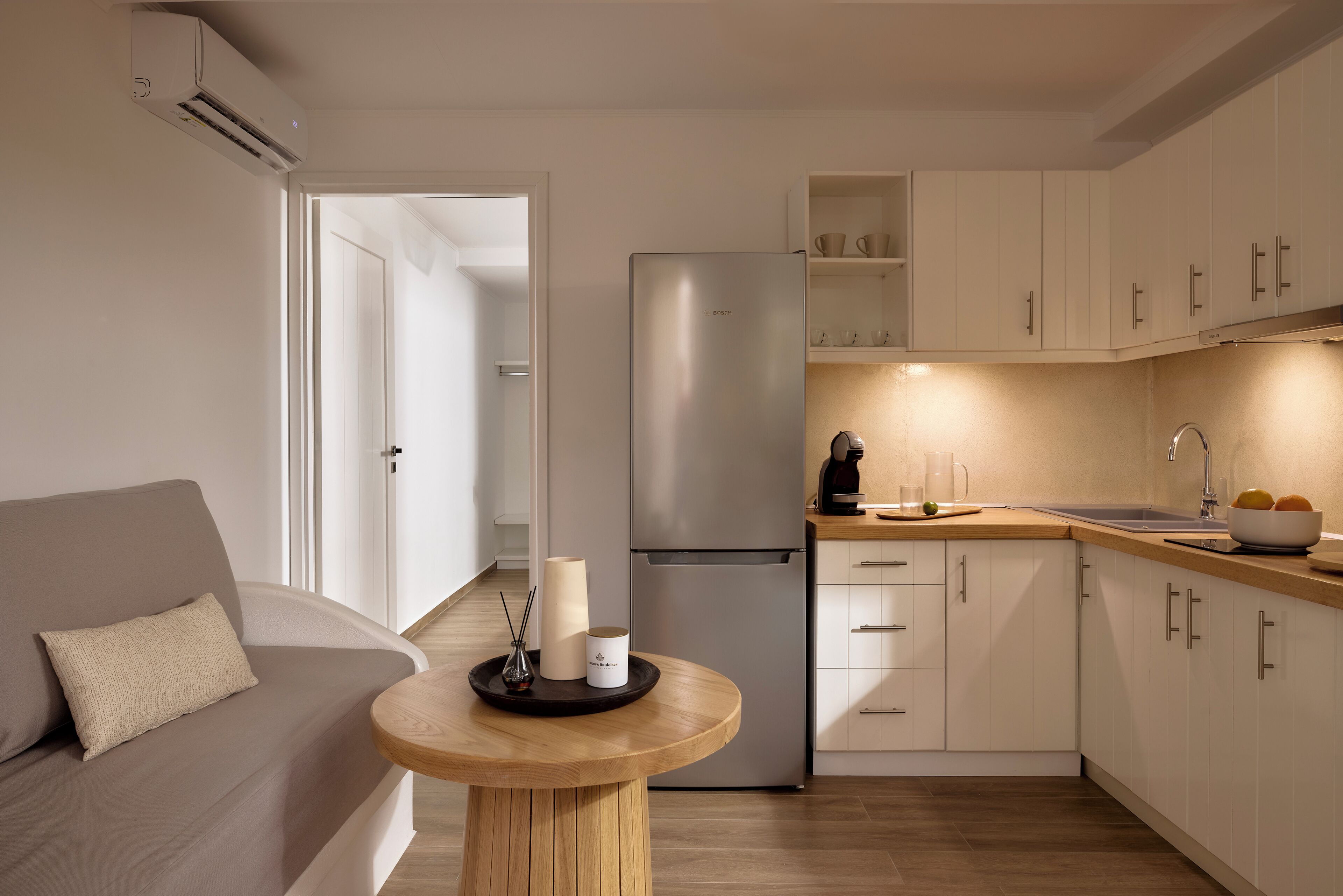 Une cuisine moderne équipée d’un réfrigérateur, de placards et d’un coin repas avec une table et des chaises.