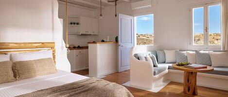 Une chambre à coucher avec un lit, un banc en bois, un canapé et une petite table.