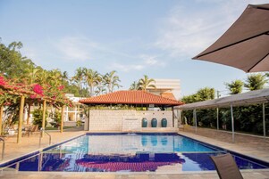 Una piscina al aire libre, sillones reclinables de piscina