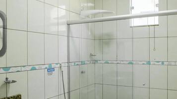 A bathroom with a toilet, a shower enclosure, and a sink with a granite countertop.