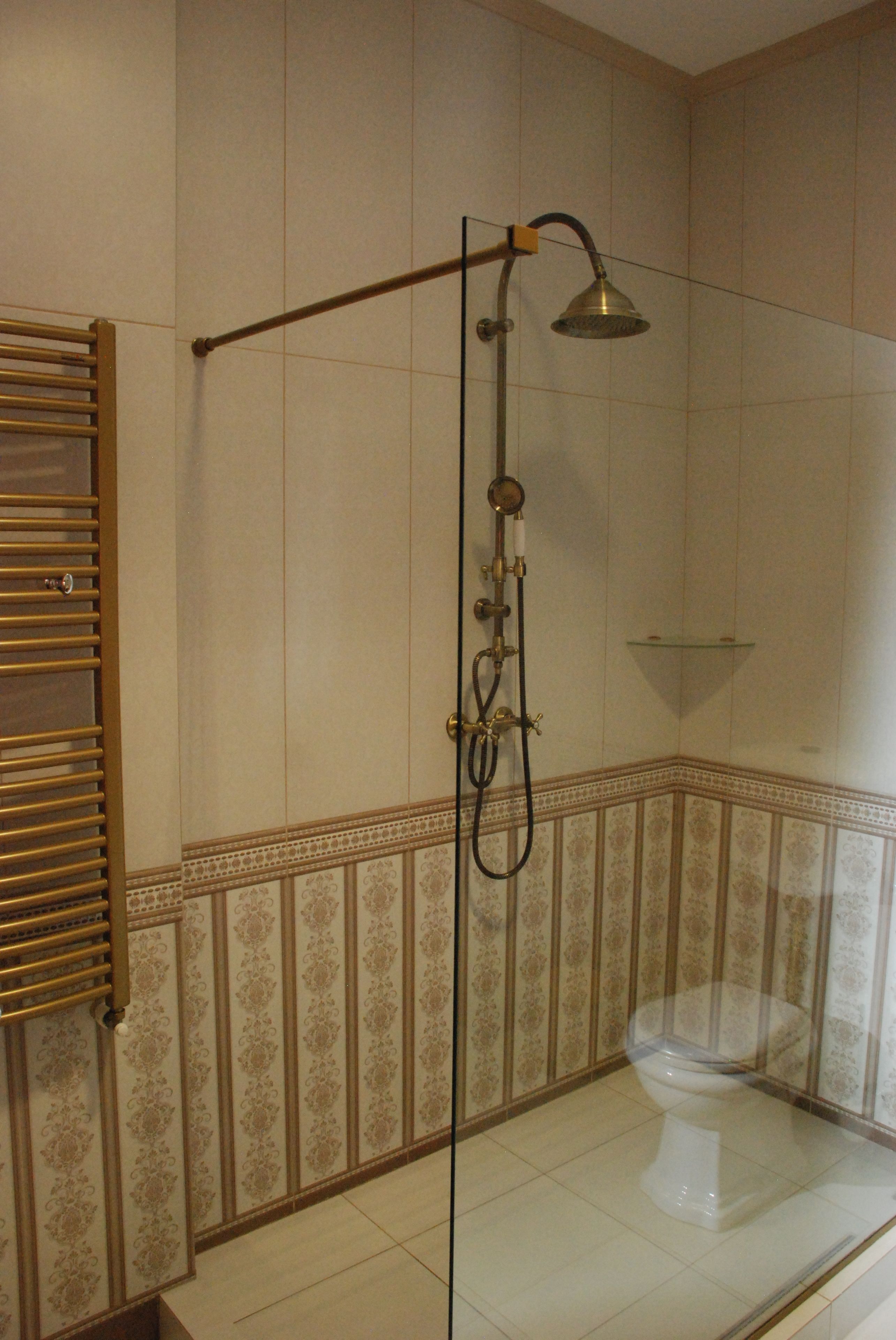 Un baño con ducha, inodoro y perchero para toallas.