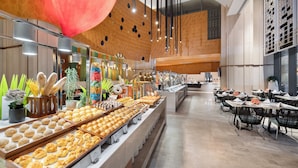 Ein Buffet mit verschiedenen Speisen und eine Sitzgelegenheit mit Tischen und Stühlen.