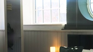 A hotel room with a bed, a bedside lamp, a window, and a view of the outside.