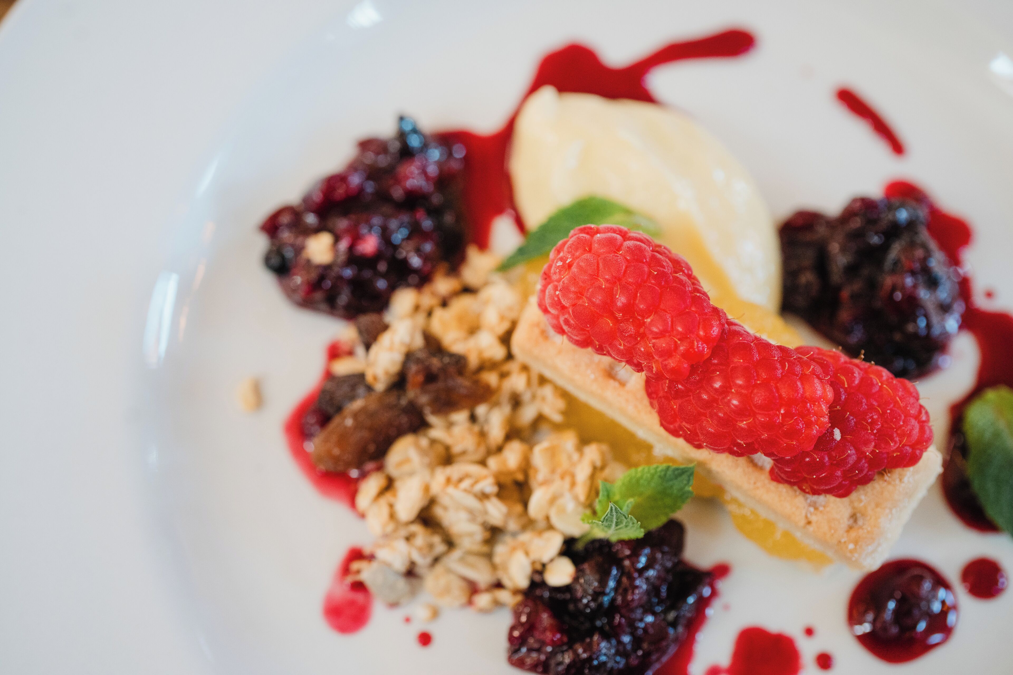 A dessert plate with various fruits and granola.