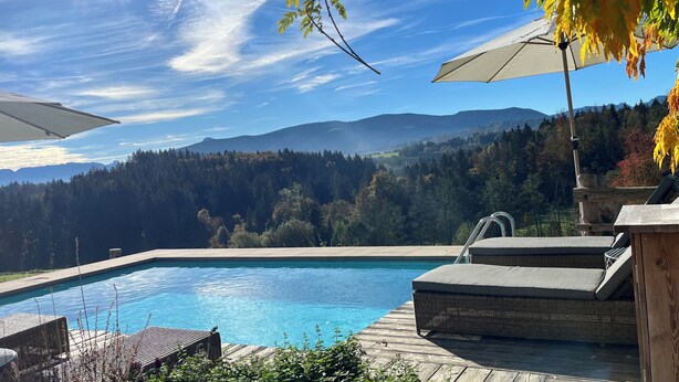 A swimming pool with a wooden deck, lounge chairs, and umbrellas. - "Melkerhaus" bis 6 Personen mit Terrasse und Pool, 101m² (Wonneberg)
