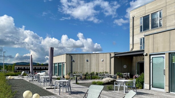 Un patio moderno al aire libre con mobiliario y vistas a un edificio.