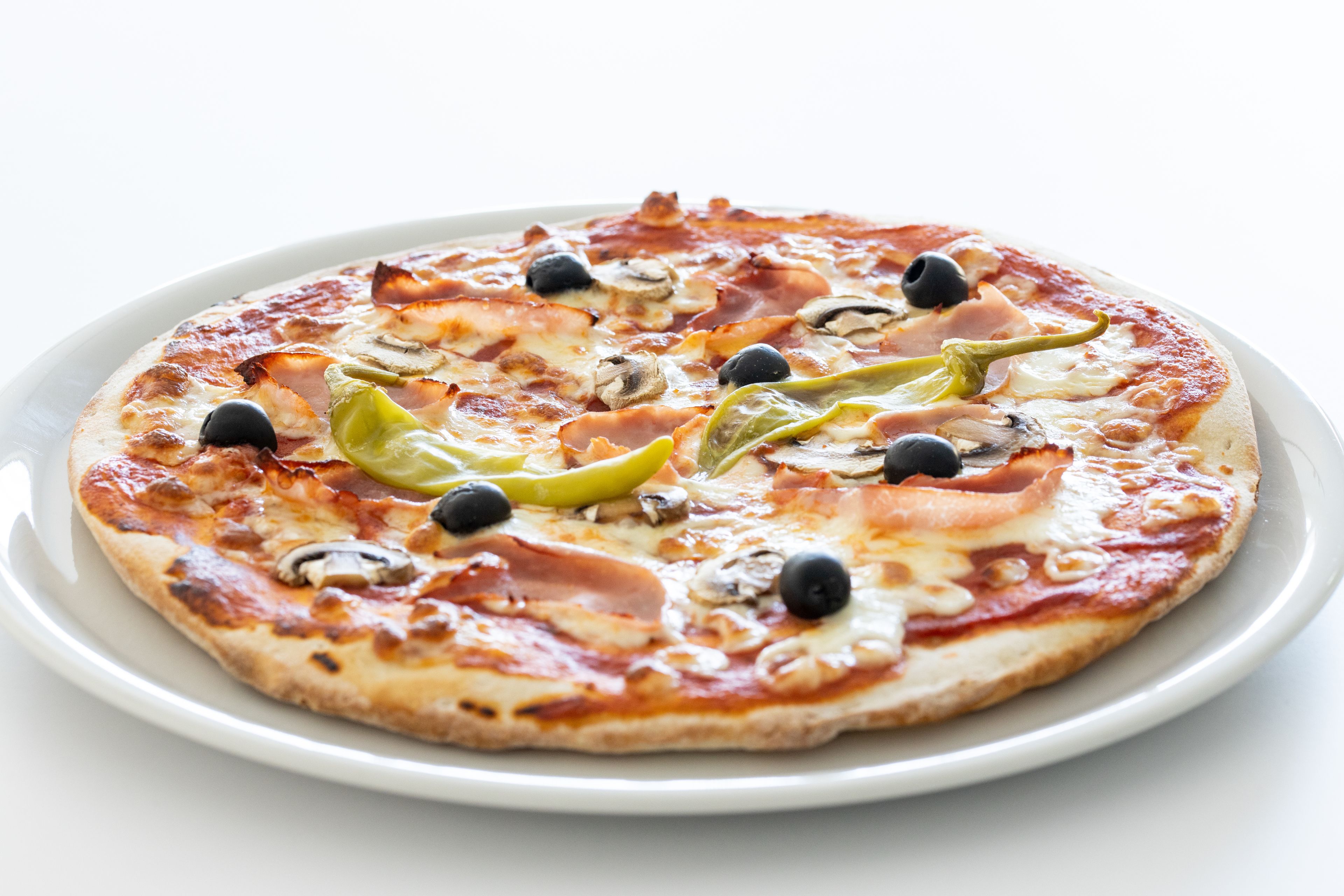 Una pizza con diferentes ingredientes sobre un plato blanco.