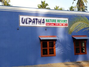 A building with a sign that reads "VCPATHA NATURE RESORT" and a hot line number.