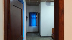 A hallway with a wooden door, a blue curtain, and a tiled ceiling. - Ulpatha Nature Resort (Kobeigane)