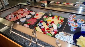 Un bufé con diferentes carnes, quesos y productos lácteos.