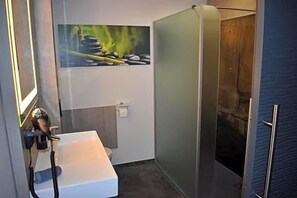 Un baño con bañera, cabina de ducha y toallero de pared.