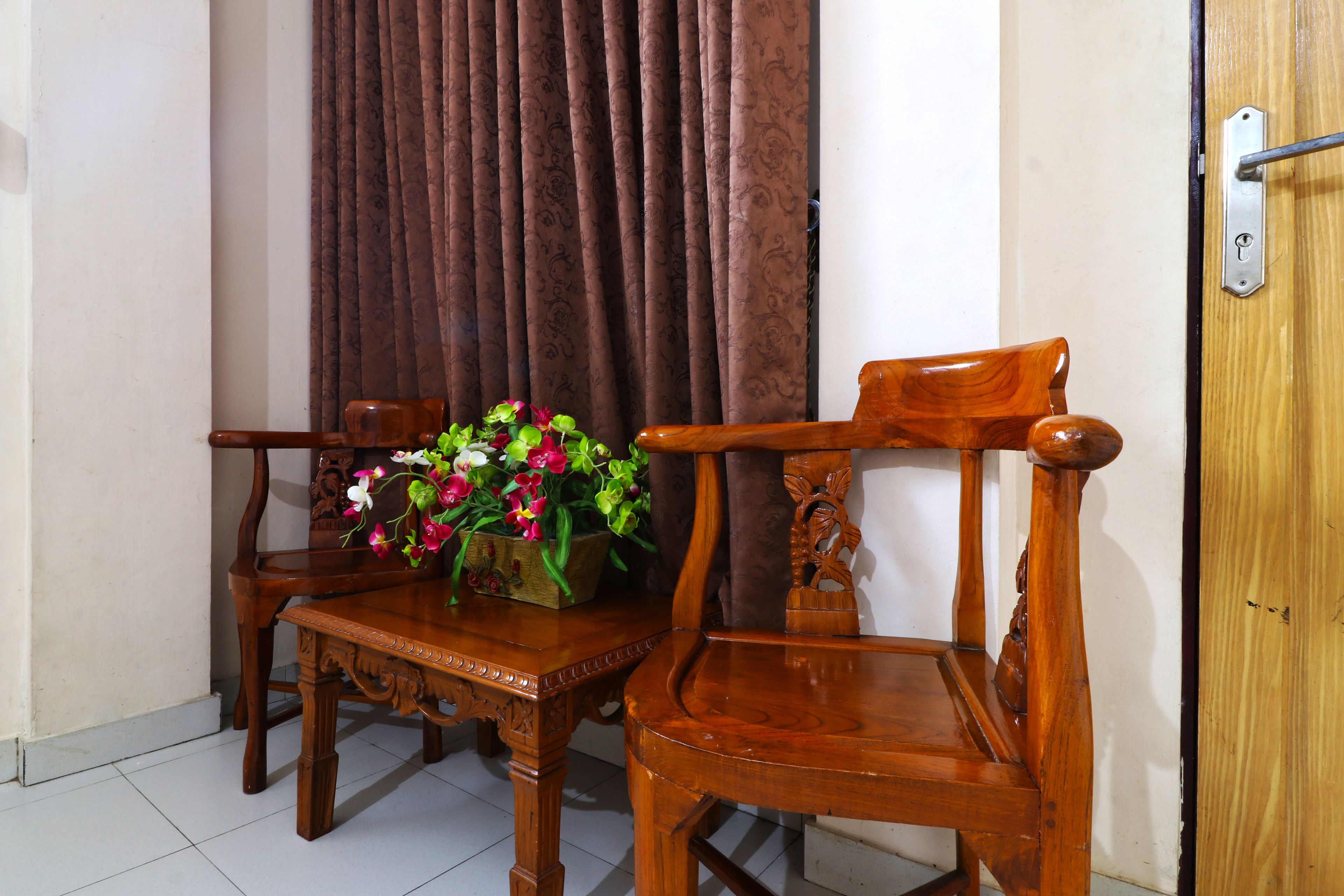 A wooden dining table with chairs and a vase of flowers.