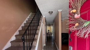 A staircase leading to a dining area with a red door. - Cozy Stone Mountain Villa (Stone Mountain)
