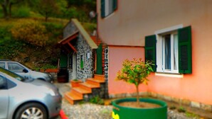 Ein Hausmodell mit kleinem Garten, einem Auto und einer Treppe.