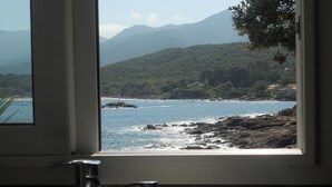 Une cuisine avec une fenêtre donnant sur un paysage côtier.