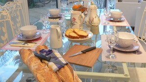 A dining table set with bread, a knife, a bowl, a pitcher, and a plate of fruit. - La Maison de l'étang (Sampigny)