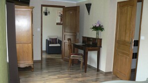 A bedroom with a bed, a wooden desk, a chair, and a wardrobe. - La Maison de l'étang (Sampigny)