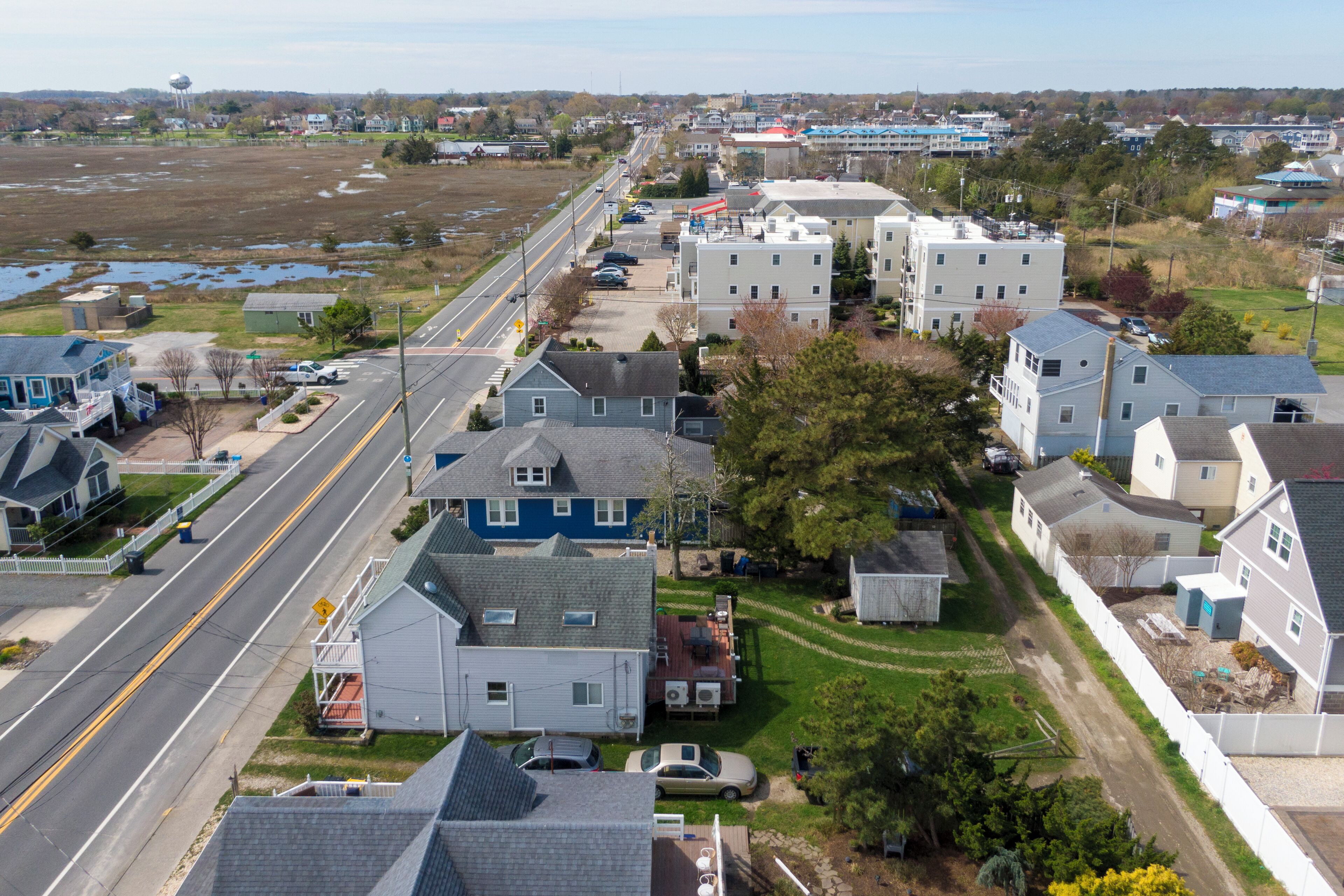 A residential area with houses, a road, and a water tower in the background.